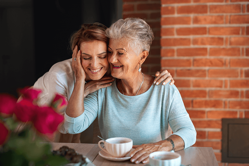 Happy senior mother embracing with adult daughter